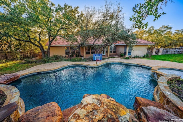 view of swimming pool featuring a fenced in pool, an in ground hot tub, and fence
