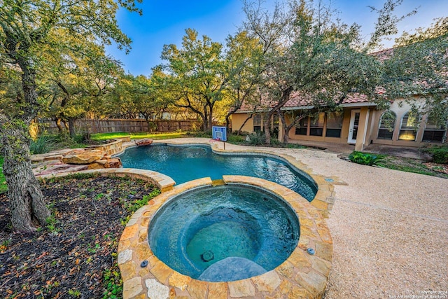 view of pool with a patio, a pool with connected hot tub, and fence