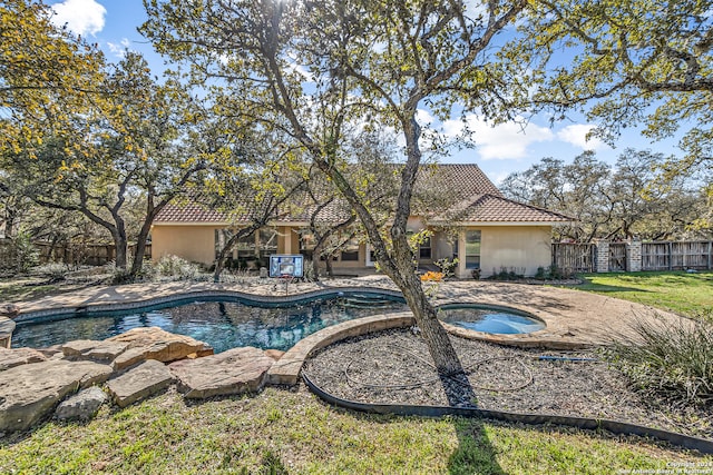view of swimming pool featuring a fenced in pool, fence, a yard, an in ground hot tub, and a patio