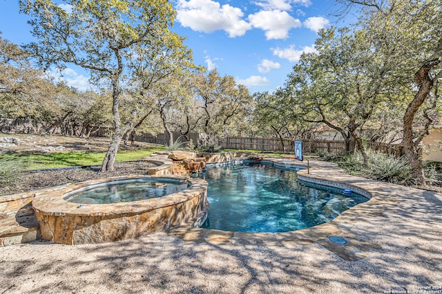 view of swimming pool with a pool with connected hot tub and a fenced backyard