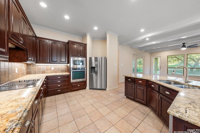 kitchen with a sink, tasteful backsplash, appliances with stainless steel finishes, crown molding, and light tile patterned floors