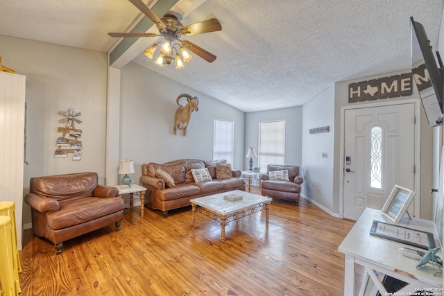 living room featuring ceiling fan, a textured ceiling, and light hardwood / wood-style flooring