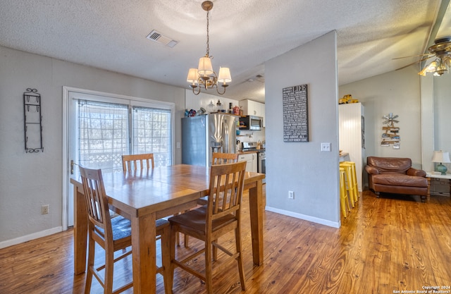 dining area featuring a textured ceiling, ceiling fan with notable chandelier, and hardwood / wood-style flooring