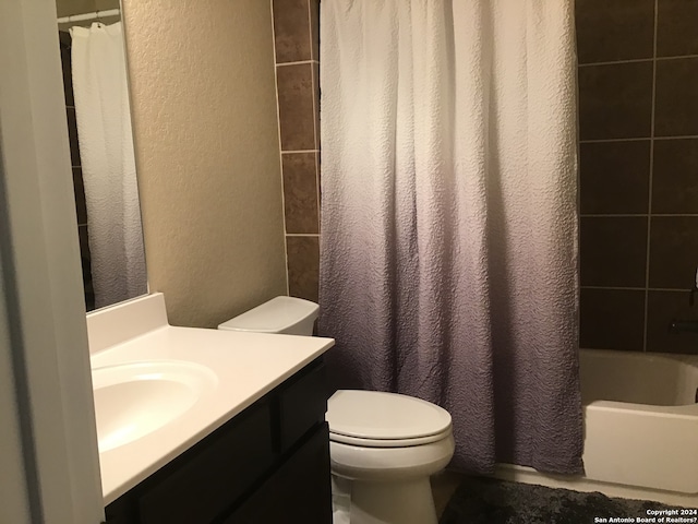 full bathroom featuring shower / bath combo with shower curtain, toilet, and vanity with extensive cabinet space