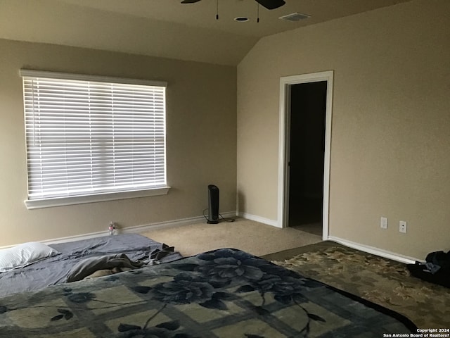 unfurnished bedroom with light carpet, multiple windows, ceiling fan, and vaulted ceiling