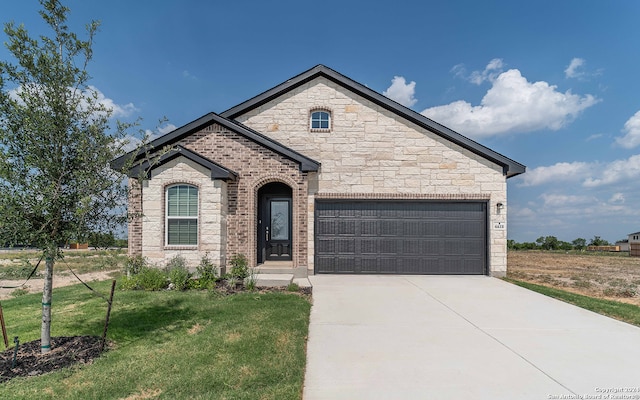 view of front of home featuring a front yard and a garage