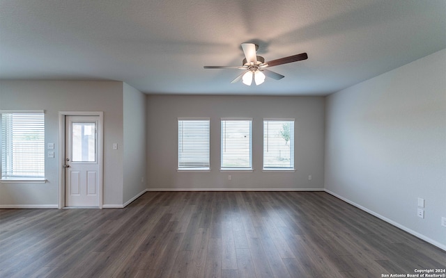 unfurnished room featuring dark hardwood / wood-style flooring, ceiling fan, and a textured ceiling