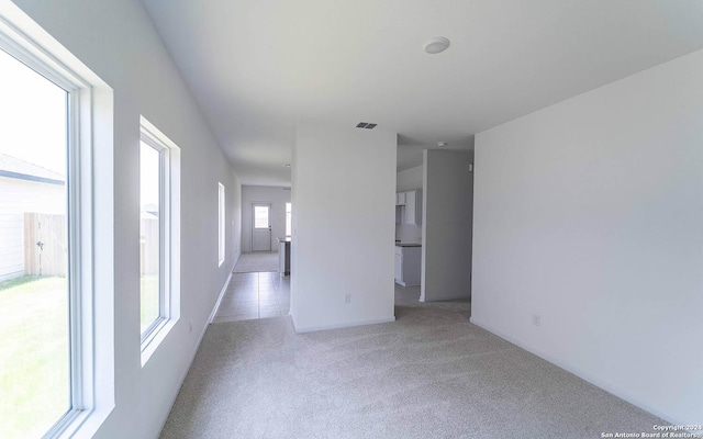 carpeted spare room with baseboards and visible vents