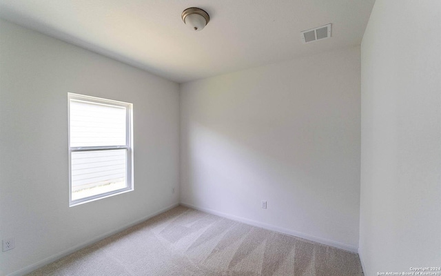 empty room featuring visible vents, carpet, and baseboards