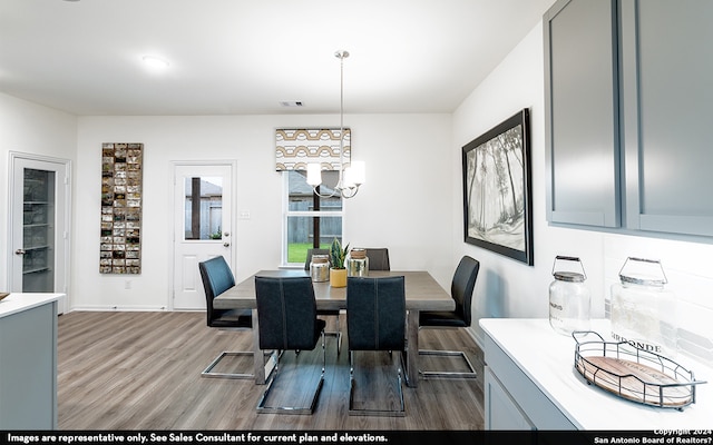 dining space featuring dark hardwood / wood-style floors and an inviting chandelier