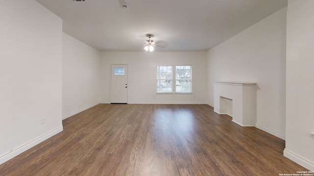 unfurnished living room featuring ceiling fan and dark hardwood / wood-style flooring