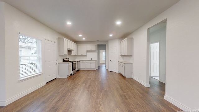 kitchen with white cabinetry, range, hardwood / wood-style flooring, and a healthy amount of sunlight