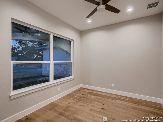 empty room with ceiling fan and light wood-type flooring