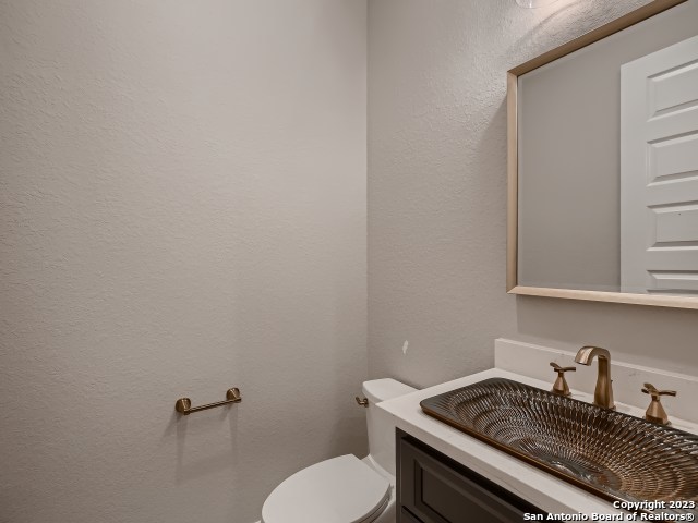 bathroom featuring toilet and vanity with extensive cabinet space