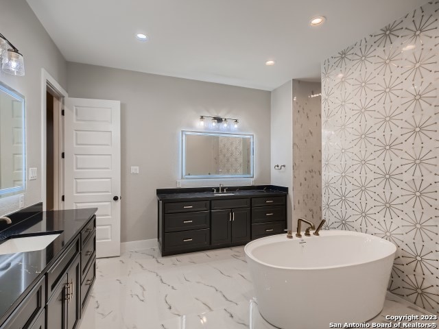 bathroom with a washtub, dual vanity, and tile flooring