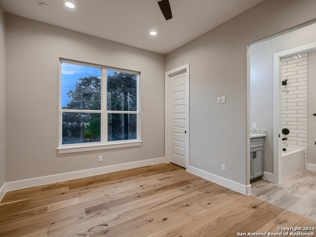 unfurnished room with ceiling fan and light hardwood / wood-style flooring