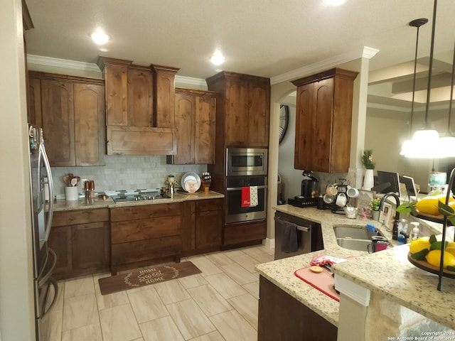 kitchen featuring pendant lighting, stainless steel appliances, light stone countertops, crown molding, and sink