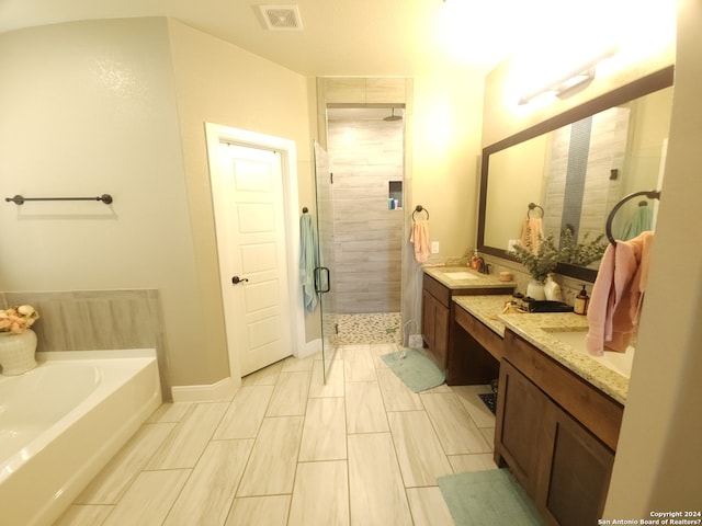 bathroom with shower with separate bathtub, double vanity, and tile floors