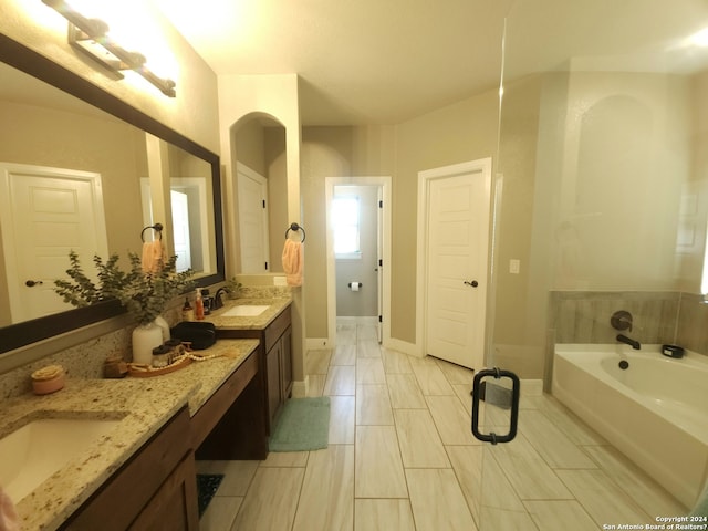 bathroom featuring tile flooring, a bathtub, and double vanity