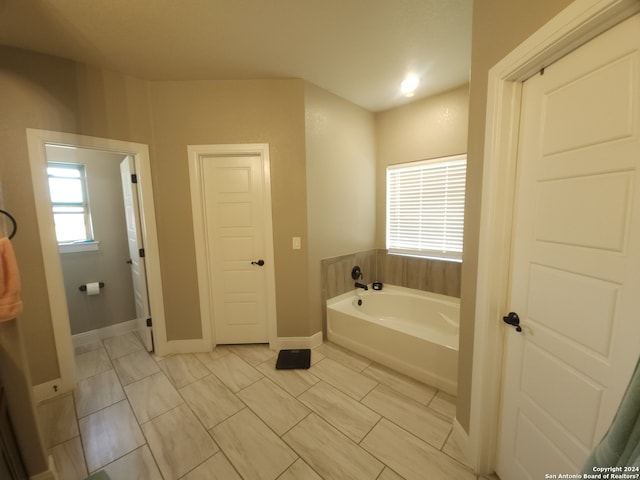 bathroom with a bathing tub and tile floors