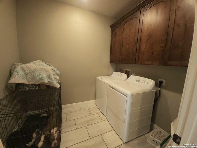 laundry area with washer hookup, electric dryer hookup, light tile floors, cabinets, and washing machine and dryer