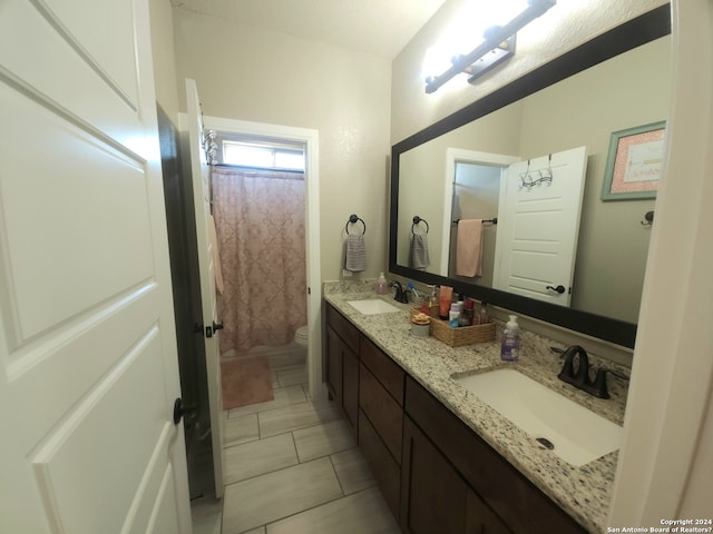 bathroom featuring double vanity, toilet, and tile floors