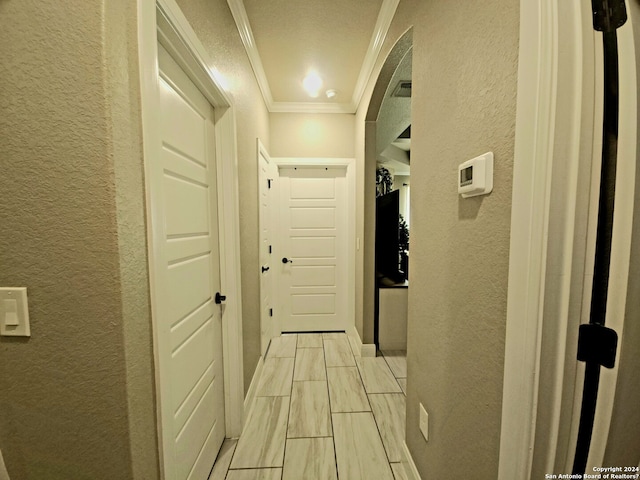 corridor with ornamental molding and light tile floors