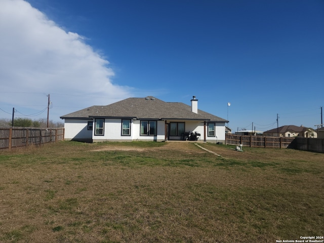 rear view of property with a yard