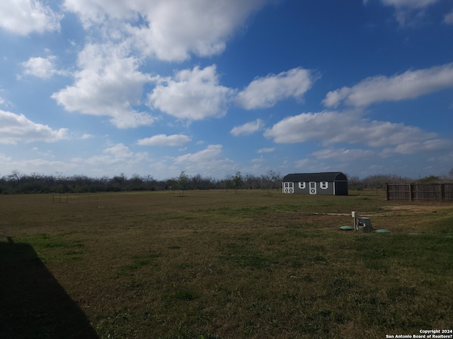 view of yard with a rural view and an outdoor structure