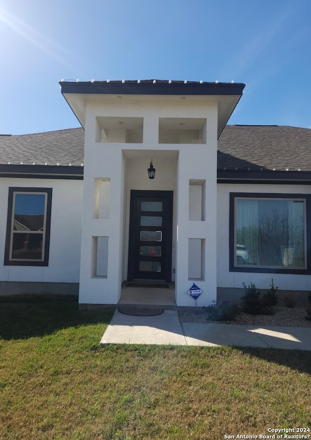 view of exterior entry with a yard