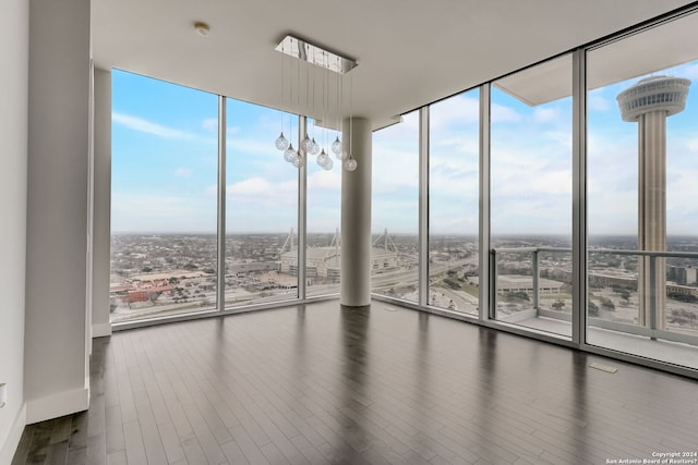 unfurnished room featuring a wall of windows and dark hardwood / wood-style flooring