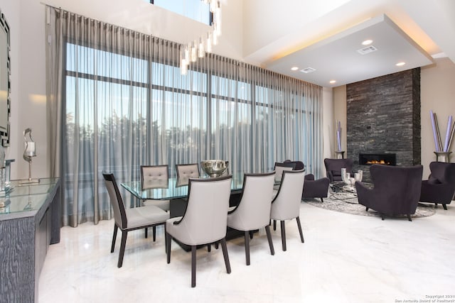 tiled dining area with a healthy amount of sunlight and a stone fireplace