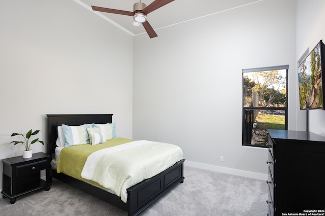 carpeted bedroom featuring ceiling fan, crown molding, and a towering ceiling