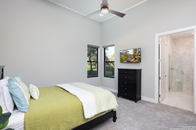 carpeted bedroom with connected bathroom, high vaulted ceiling, and ceiling fan