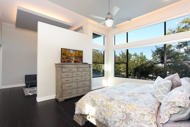 bedroom with dark hardwood / wood-style floors, ceiling fan, and a high ceiling