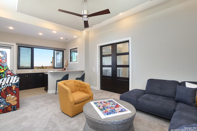 living room with light colored carpet, ceiling fan, and french doors