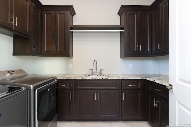 clothes washing area featuring cabinets, sink, light tile floors, and independent washer and dryer