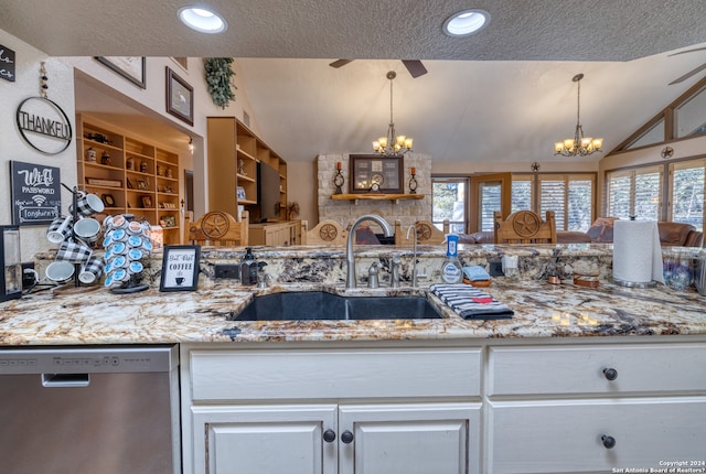 kitchen featuring lofted ceiling, sink, a textured ceiling, dishwasher, and pendant lighting