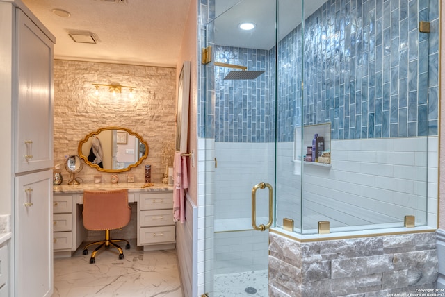 bathroom with an enclosed shower, vanity, a textured ceiling, and tile floors