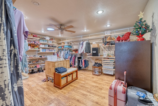 spacious closet featuring light hardwood / wood-style flooring and ceiling fan