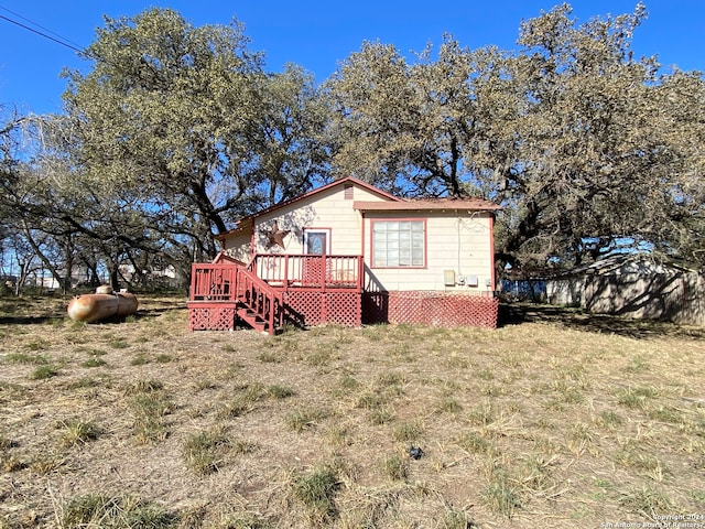 back of house featuring a wooden deck and a yard