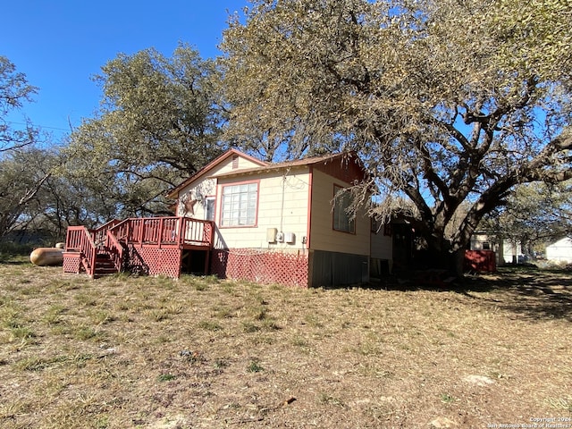 back of house with a yard and a deck