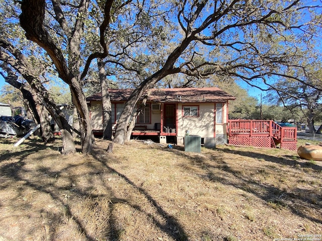 rear view of house featuring a yard and a wooden deck