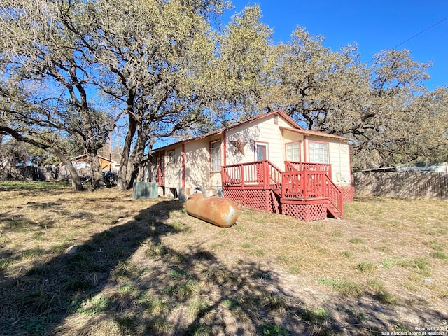 rear view of house featuring a yard and a deck