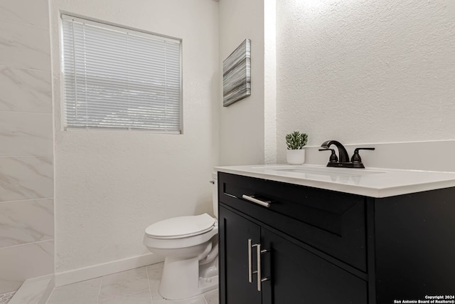 bathroom featuring tile patterned flooring, vanity, and toilet