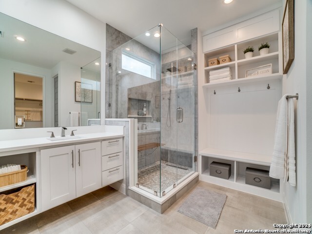 bathroom featuring an enclosed shower, large vanity, and tile flooring