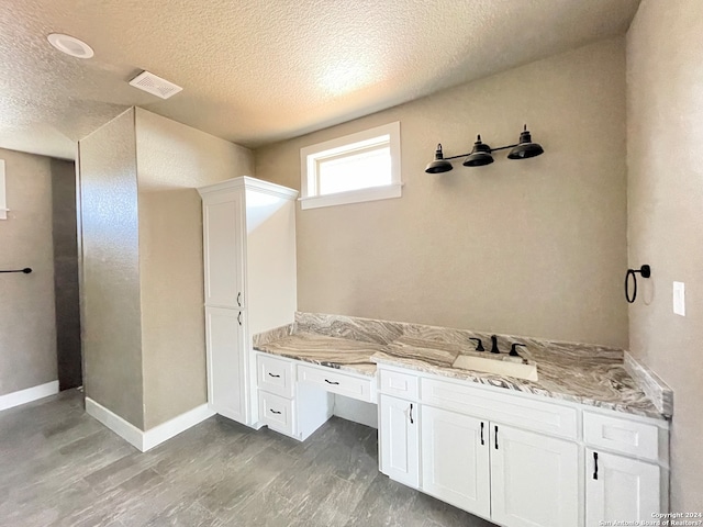 bathroom with sink, hardwood / wood-style floors, and a textured ceiling