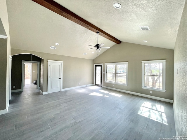 spare room with light hardwood / wood-style floors, ceiling fan, and lofted ceiling with beams