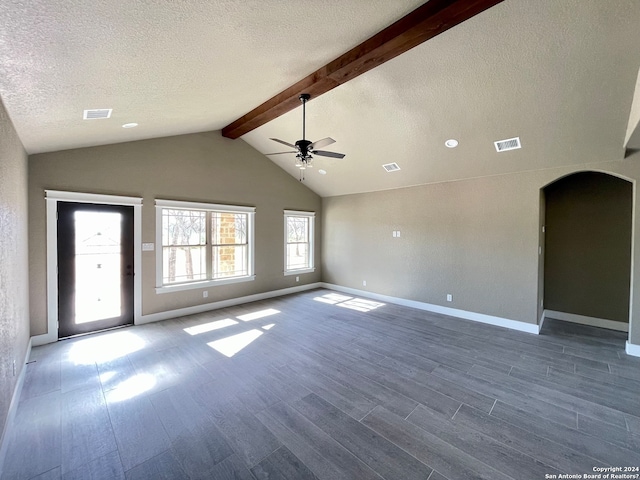 spare room with lofted ceiling with beams, dark hardwood / wood-style floors, a textured ceiling, and ceiling fan