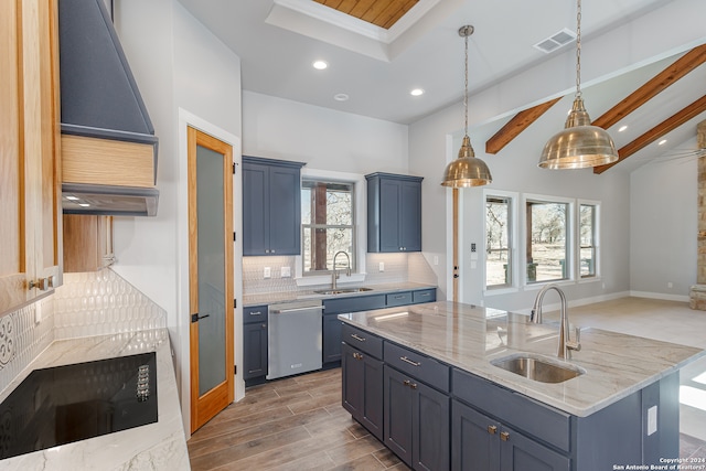 kitchen with stainless steel dishwasher, sink, beamed ceiling, and an island with sink